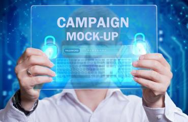 A man holding a screen in front of his face that reads "Campaign Mock-Up"