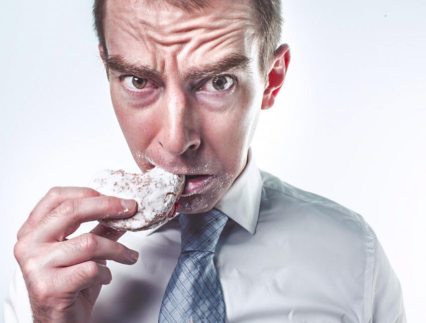 A man looking upset as he eats a cookie